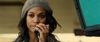 Movie still from “Colombiana” (2011), directed by Olivier Megaton – A young woman wearing a hat is talking on a phone; Close Up shot, High angle