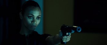 Movie still from “Colombiana” (2011), directed by Olivier Megaton – A woman holding a gun in a dark room; Close Up shot, Over the shoulder angle