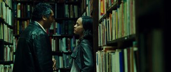 Movie still from “Colombiana” (2011), directed by Olivier Megaton – A woman standing in front of a book shelf; Medium shot, Over the shoulder angle