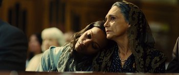 Movie still from “Colombiana” (2011), directed by Olivier Megaton – A woman and a woman sitting next to each other in a room; Close Up shot, Low angle