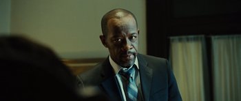 Movie still from “Colombiana” (2011), directed by Olivier Megaton – A man wearing a suit and tie in front of a mirror; Close Up shot, Over the shoulder angle