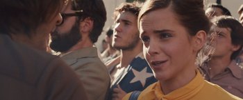 Movie still from “Colonia” (2015), directed by Florian Gallenberger – A group of people standing next to each other on a street; Close Up shot, Over the shoulder angle
