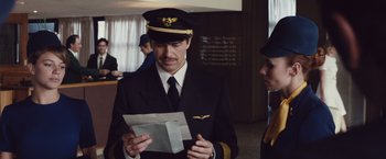Movie still from “Colonia” (2015), directed by Florian Gallenberger – A man in a pilot's uniform looking at a piece of paper; Medium shot, Low angle