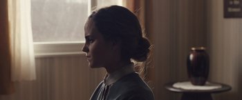 Movie still from “Colonia” (2015), directed by Florian Gallenberger – A woman with a bun is looking out the window; Close Up shot, Over the shoulder angle