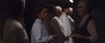 Movie still from “Colonia” (2015), directed by Florian Gallenberger – A group of people standing next to each other in a room; Medium shot, Over the shoulder angle