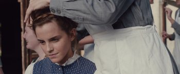 Movie still from “Colonia” (2015), directed by Florian Gallenberger – A woman with her hair in a bun is sitting next to a man; Close Up shot, Over the shoulder angle