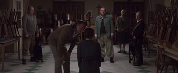 Movie still from “Colonia” (2015), directed by Florian Gallenberger – A group of people standing in a room; Medium shot, Over the shoulder angle