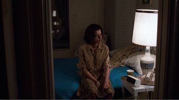 Movie still from “Coma” (1978), directed by Michael Crichton – A woman sitting on a bed in front of a lamp; Medium shot, High angle