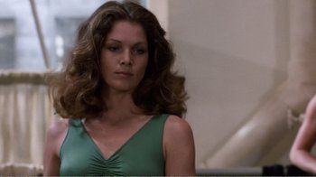 Movie still from “Coma” (1978), directed by Michael Crichton – A woman in a green dress is looking at the camera; Close Up shot, Low angle