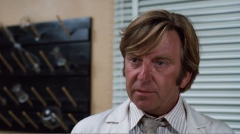 Movie still from “Coma” (1978), directed by Michael Crichton – A person wearing a suit and tie; Close Up shot, Low angle