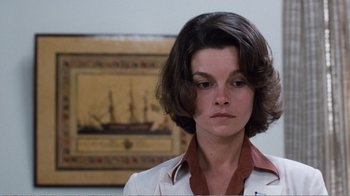 Movie still from “Coma” (1978), directed by Michael Crichton – A woman with short brown hair wearing a white shirt; Close Up shot, Low angle