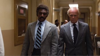 Movie still from “Coma” (1978), directed by Michael Crichton – Two men in suits walking down a hall way; Medium shot, Low angle