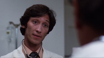 Movie still from “Coma” (1978), directed by Michael Crichton – A man in a white lab coat looking at himself in the mirror; Close Up shot, Low angle