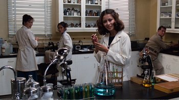 Movie still from “Coma” (1978), directed by Michael Crichton – Two women in lab coats in front of lab equipment; Medium shot, Over the shoulder angle