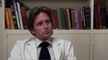 Movie still from “Coma” (1978), directed by Michael Crichton – A man wearing a white jacket and a black tie; Close Up shot, Over the shoulder angle