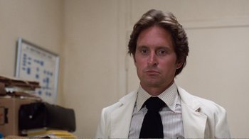 Movie still from “Coma” (1978), directed by Michael Crichton – A person wearing a suit and tie; Close Up shot, Over the shoulder angle