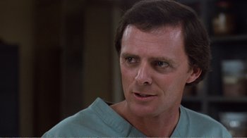 Movie still from “Coma” (1978), directed by Michael Crichton – A person wearing a blue shirt; Close Up shot, Low angle