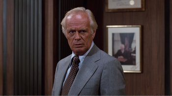 Movie still from “Coma” (1978), directed by Michael Crichton – An older man wearing a suit and tie; Close Up shot, Over the shoulder angle