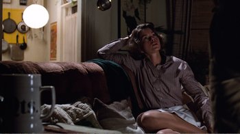 Movie still from “Coma” (1978), directed by Michael Crichton – A woman sitting on a couch in a living room; Medium shot, Low angle