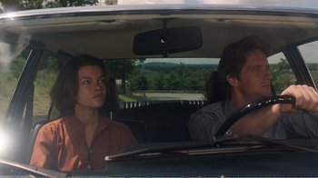 Movie still from “Coma” (1978), directed by Michael Crichton – A man and a woman sitting in the back of a car; Medium shot, Low angle