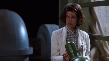Movie still from “Coma” (1978), directed by Michael Crichton – A woman in a white jacket holding a green object; Medium shot, Low angle