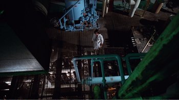 Movie still from “Coma” (1978), directed by Michael Crichton – An overhead view of a man in a white suit in an industrial setting; Extreme Wide shot, Overhead angle