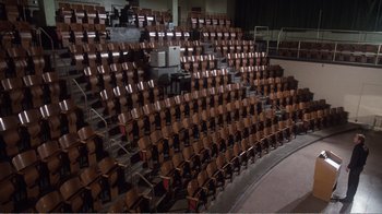 Movie still from “Coma” (1978), directed by Michael Crichton – Many rows of wooden chairs in a large room; Extreme Wide shot, High angle