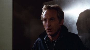 Movie still from “Coma” (1978), directed by Michael Crichton – A person wearing a black jacket; Close Up shot, Low angle