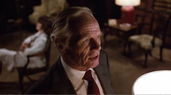 Movie still from “Coma” (1978), directed by Michael Crichton – An older man wearing a suit and a red neck tie; Close Up shot, Over the shoulder angle