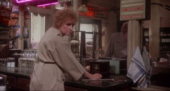 Movie still from “Come Back to the 5 & Dime Jimmy Dean, Jimmy Dean” (1982), directed by Robert Altman – An older woman is leaning over a counter in a restaurant; Medium shot, Over the shoulder angle