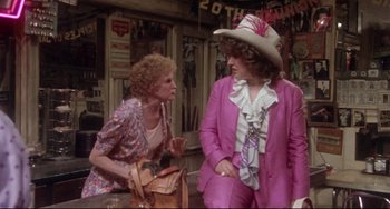 Movie still from “Come Back to the 5 & Dime Jimmy Dean, Jimmy Dean” (1982), directed by Robert Altman – Two women in pink suits and a white hat talking; Medium shot, Over the shoulder angle