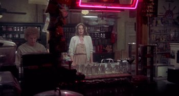 Movie still from “Come Back to the 5 & Dime Jimmy Dean, Jimmy Dean” (1982), directed by Robert Altman – A woman standing in front of a mirror in a kitchen; Medium shot, Over the shoulder angle