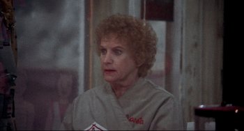Movie still from “Come Back to the 5 & Dime Jimmy Dean, Jimmy Dean” (1982), directed by Robert Altman – An older woman with curly blonde hair wearing an apron; Close Up shot, Over the shoulder angle