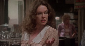 Movie still from “Come Back to the 5 & Dime Jimmy Dean, Jimmy Dean” (1982), directed by Robert Altman – A person with curly hair wearing a dress; Close Up shot, Over the shoulder angle