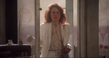 Movie still from “Come Back to the 5 & Dime Jimmy Dean, Jimmy Dean” (1982), directed by Robert Altman – A woman in a white suit holding a cigarette in her hand; Medium shot, Low angle