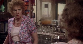 Movie still from “Come Back to the 5 & Dime Jimmy Dean, Jimmy Dean” (1982), directed by Robert Altman – An older woman sitting at a counter in front of a counter; Medium shot, Over the shoulder angle