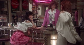 Movie still from “Come Back to the 5 & Dime Jimmy Dean, Jimmy Dean” (1982), directed by Robert Altman – Two women and a man are standing at a counter; Medium shot, Over the shoulder angle