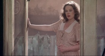 Movie still from “Come Back to the 5 & Dime Jimmy Dean, Jimmy Dean” (1982), directed by Robert Altman – A woman in a pink dress standing in front of a door; Medium shot, Low angle