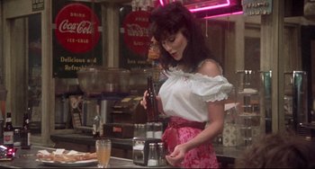 Movie still from “Come Back to the 5 & Dime Jimmy Dean, Jimmy Dean” (1982), directed by Robert Altman – A woman in white shirt and pink skirt in a kitchen; Medium shot, Over the shoulder angle