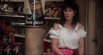 Movie still from “Come Back to the 5 & Dime Jimmy Dean, Jimmy Dean” (1982), directed by Robert Altman – A woman standing next to a bottle of root juices; Medium shot, Over the shoulder angle
