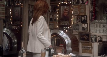 Movie still from “Come Back to the 5 & Dime Jimmy Dean, Jimmy Dean” (1982), directed by Robert Altman – A woman standing in front of an old jukebox; Medium shot, Over the shoulder angle