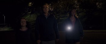 Movie still from “The Descendants” (2011), directed by Alexander Payne – A man and a woman walking in the dark with a flashlight; Medium shot, Low angle
