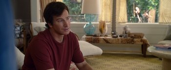 Movie still from “The Descendants” (2011), directed by Alexander Payne – A man sitting on a couch in a living room; Medium shot, Over the shoulder angle