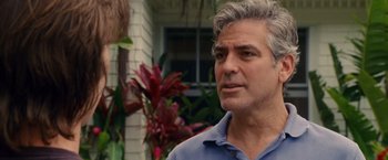 Movie still from “The Descendants” (2011), directed by Alexander Payne – A person standing near some plants; Close Up shot, Over the shoulder angle