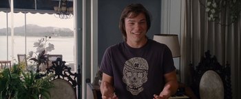 Movie still from “The Descendants” (2011), directed by Alexander Payne – A man with long hair wearing a t - shirt with an image of a skull; Medium shot, Over the shoulder angle