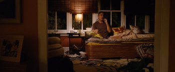 Movie still from “The Descendants” (2011), directed by Alexander Payne – A man sitting on top of a bed talking on a phone; Wide shot, High angle