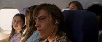 Movie still from “The Descendants” (2011), directed by Alexander Payne – A young man is listening to music on a plane; Close Up shot, Over the shoulder angle
