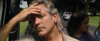 Movie still from “The Descendants” (2011), directed by Alexander Payne – A person holding his hand to his forehead; Close Up shot, Over the shoulder angle