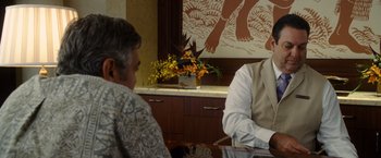 Movie still from “The Descendants” (2011), directed by Alexander Payne – Two people sitting at a table in front of a painting; Medium shot, Over the shoulder angle