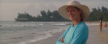 Movie still from “The Descendants” (2011), directed by Alexander Payne – A woman in a hat standing on the beach; Medium shot, Over the shoulder angle